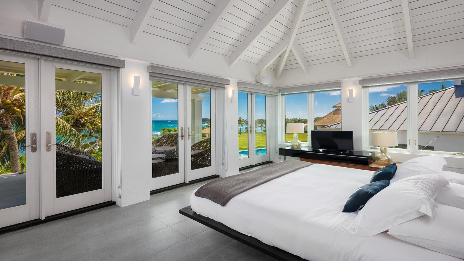 Primary bedroom with wall of glass to the ocean